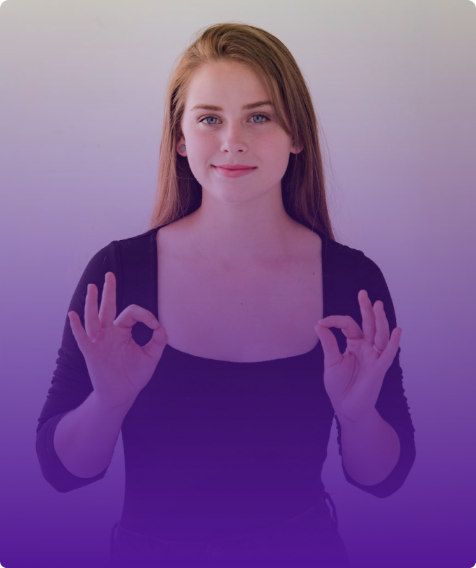 Standing in front of a white wall, with long blonde hair, blue eyes, and a black sweater; There is a girl who makes a 'zero' sign by joining her thumb and forefinger.
